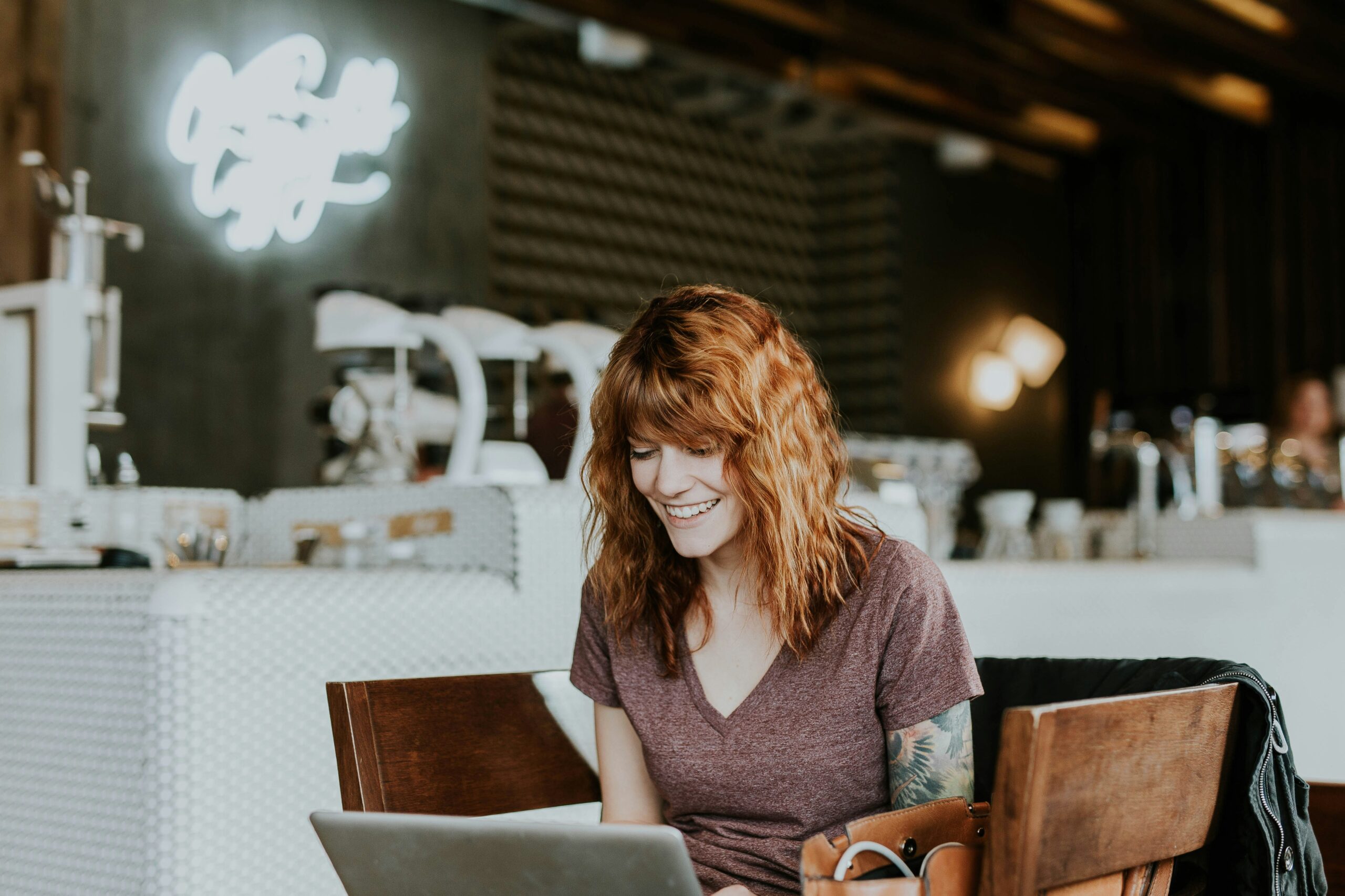 woman sitting in a coffee shop doing online therapy