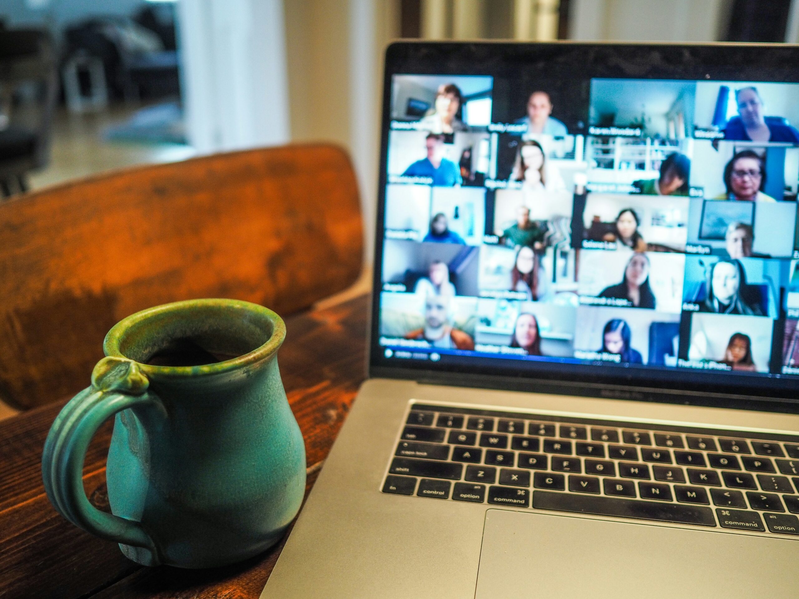 Computer screen with a group therapy session happening. Coffee cup sitting next to the screen.