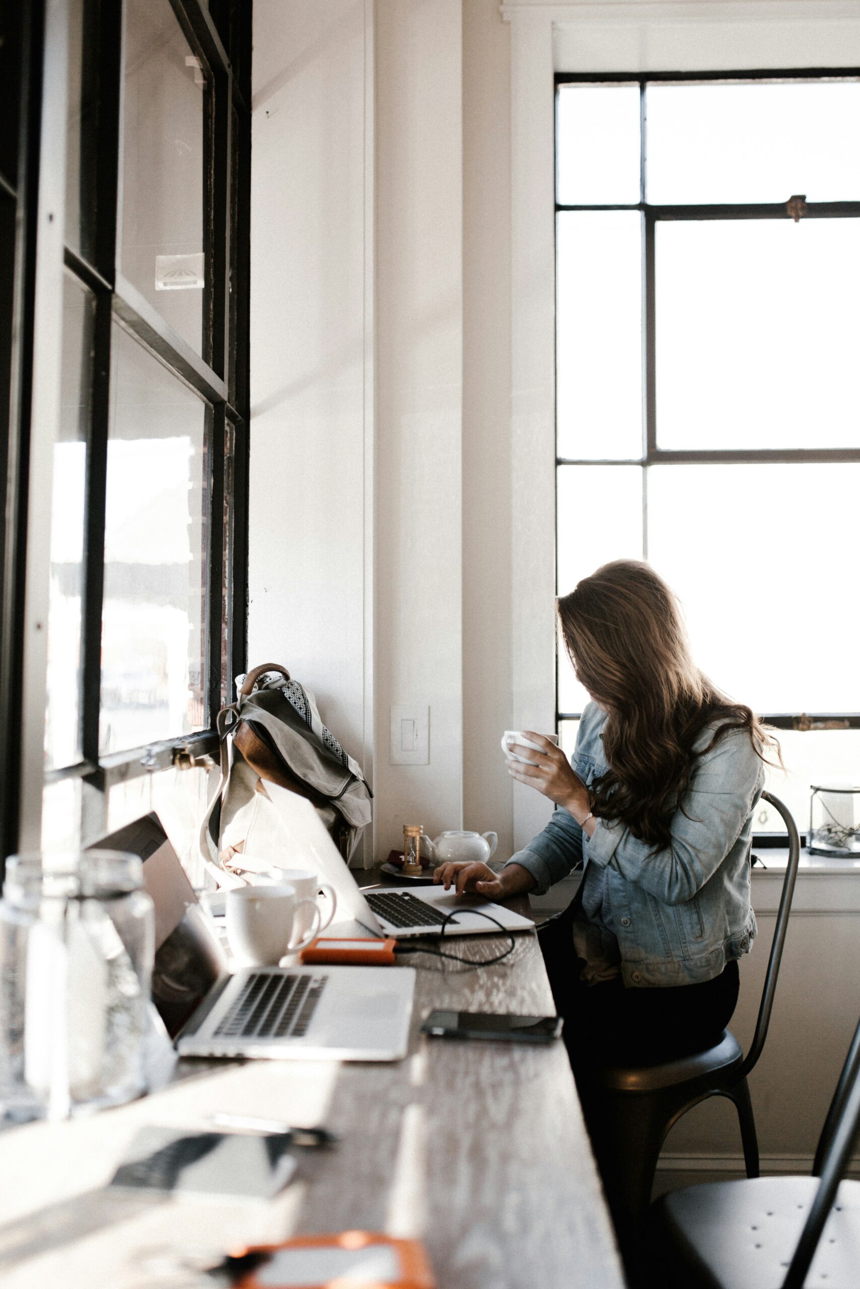 Young professional woman drinking coffee working at her computer.