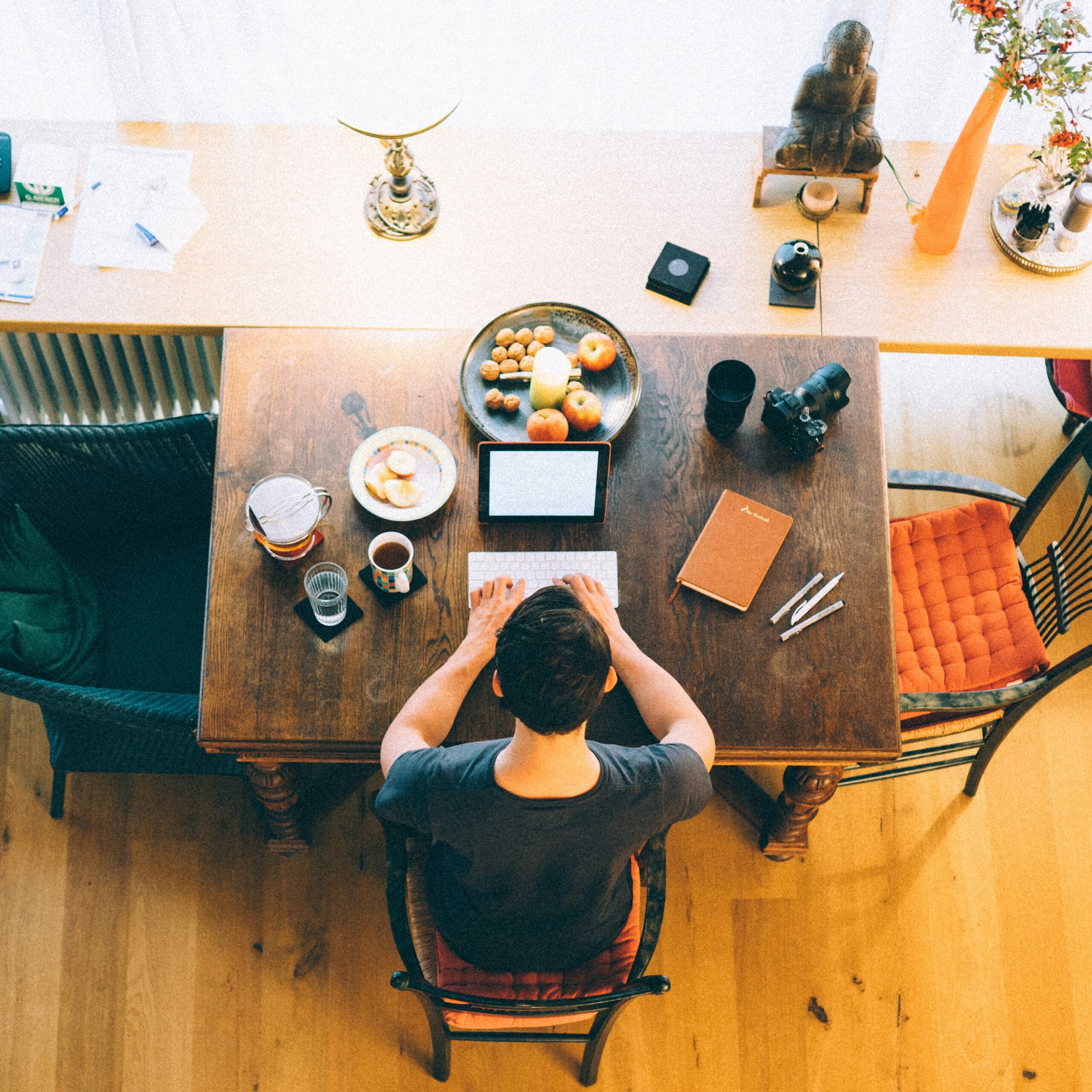 Manhattan man sitting at a table working. Anxiety can happen at work, therapy can help.