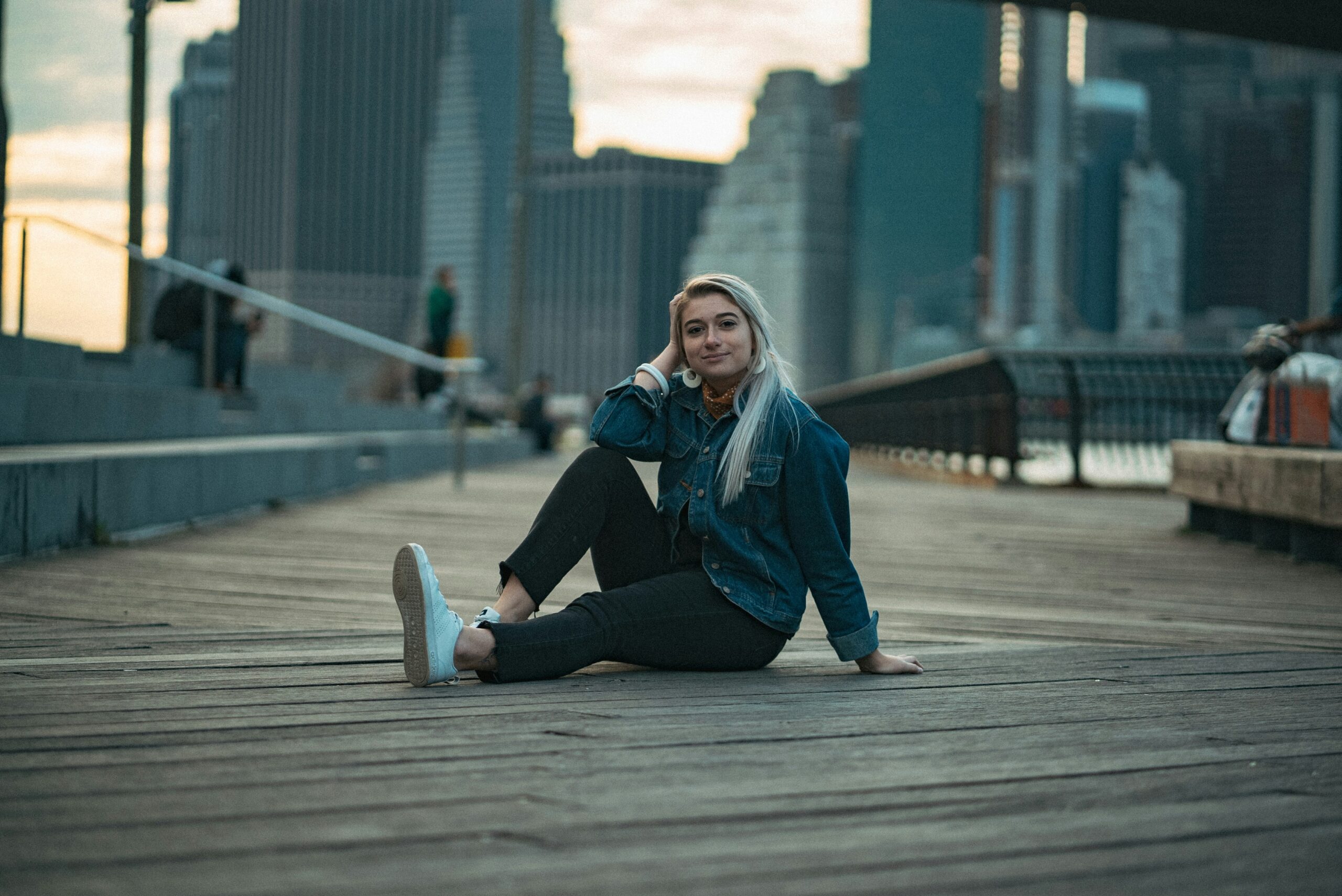 Brooklyn woman sitting on a bridge connecting her mental and physical health together as she stretches