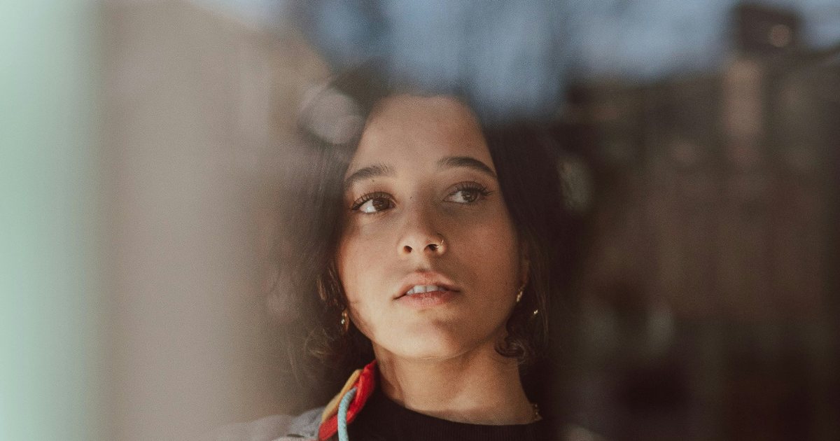 Woman thoughtfully reflecting while looking out a window